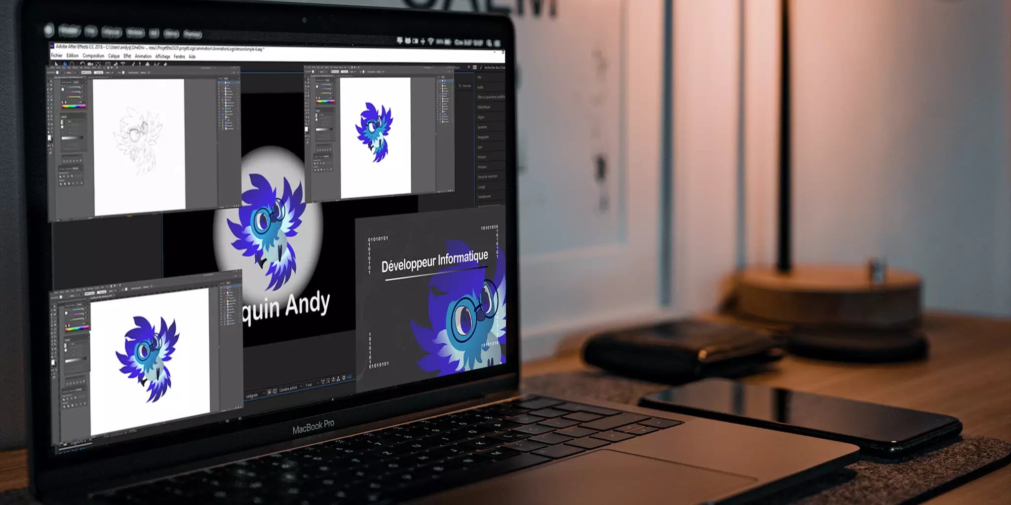 Laptop displaying various stages of a colorful owl graphic design with external mouse, smartphone, and lamp on desk